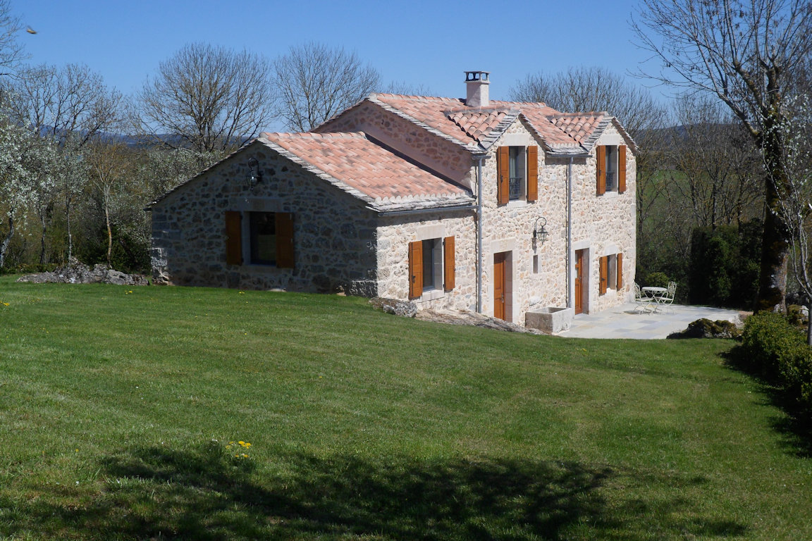 Façade en pierre du gîte Le Rouge Gorge, entourée de pelouse, à Sainte-Eulalie-de-Cernon