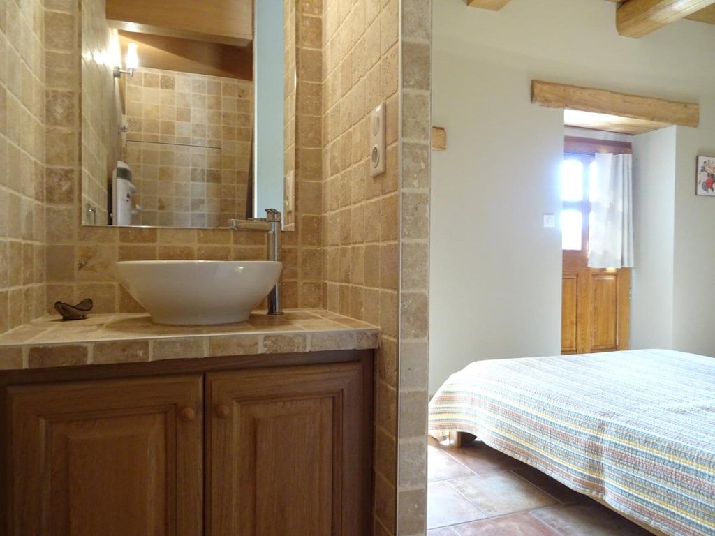 Salle d'eau privée de la chambre du rez-de-chaussée, vasque et carrelage pierre